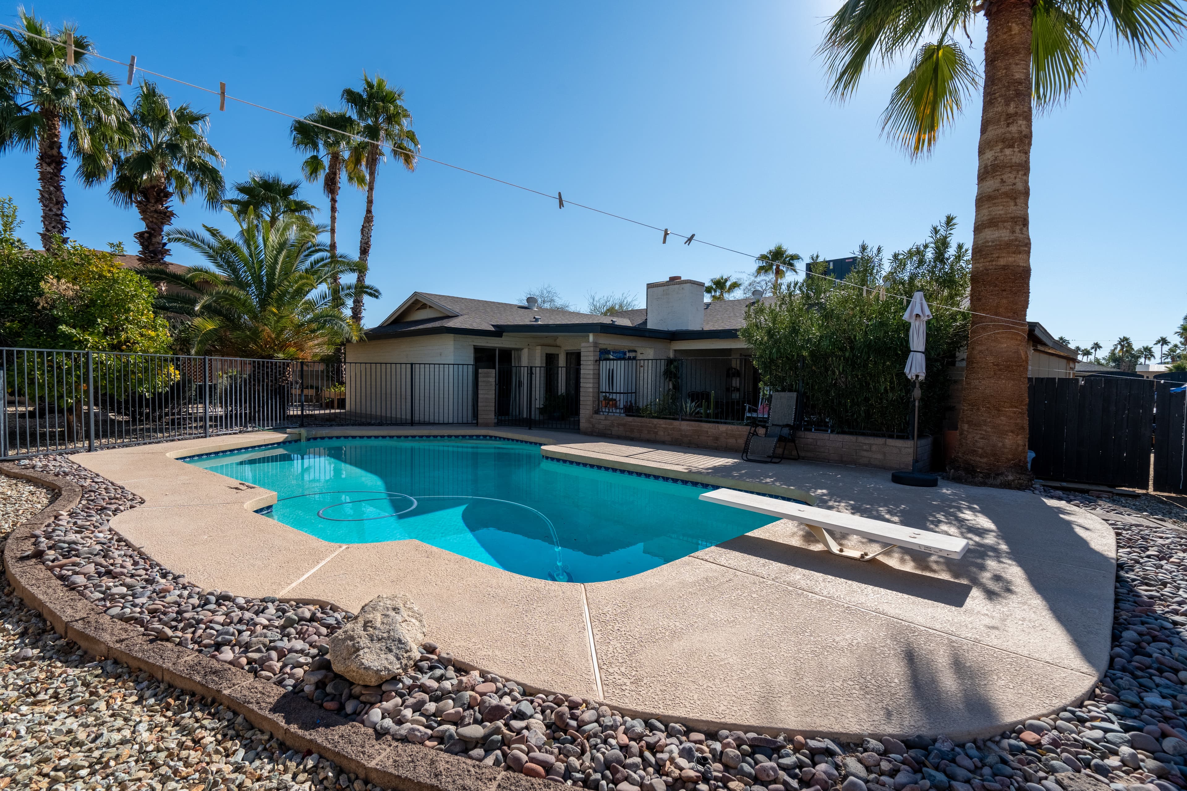 Private pool with diving board and palm trees